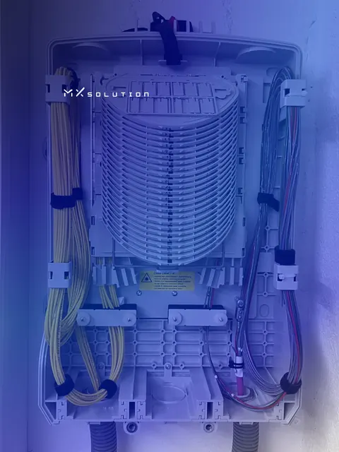 Boîtier de répartition fibre optique ouvert : pile de cassettes d'épissure numérotées et fibres jaunes rangées